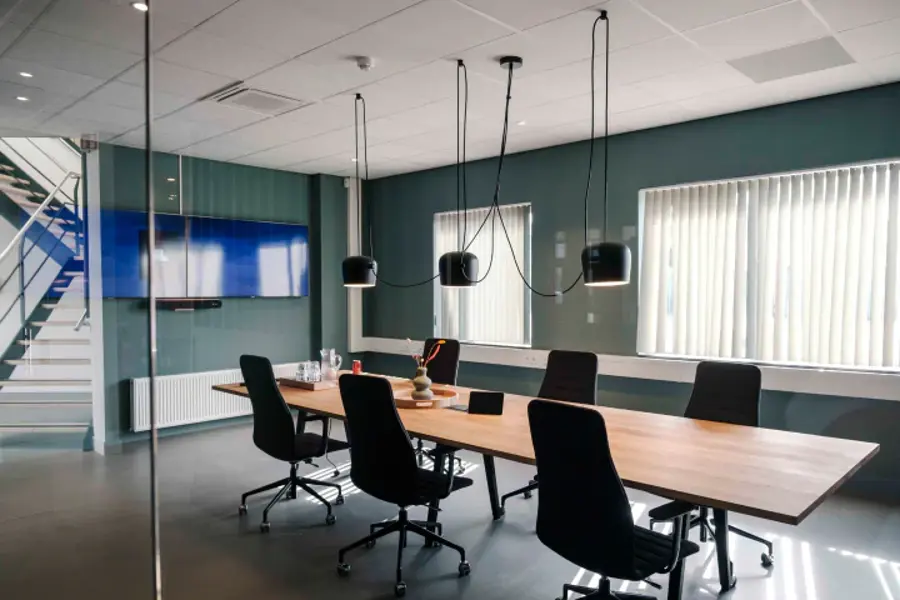 A modern office with a wooden table and chairs.