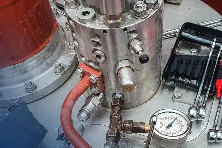 A silver and red pipe with a gauge on it.