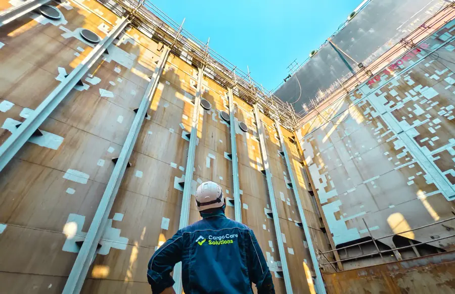 A man standing in container ship looking up.