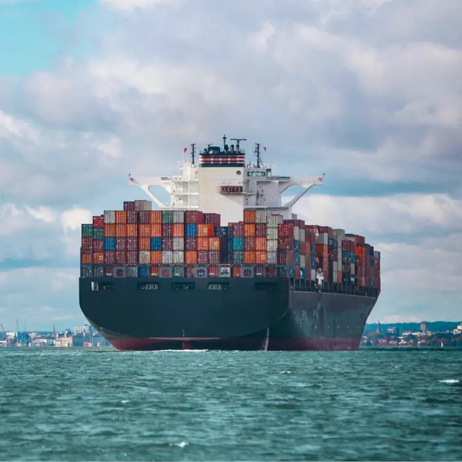 A large black ship with a white top and red bottom is floating on the water.