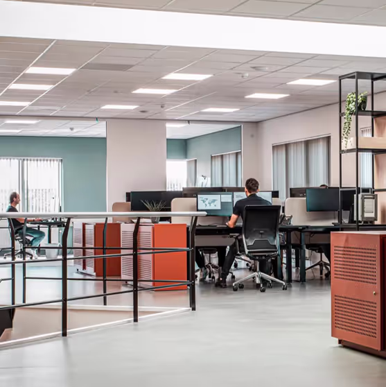 A large office with a man sitting at a desk.